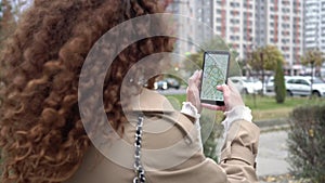 Woman outdoors holding smartphone with city map. A person hand holds a smartphone with an online maps app. GPS concept