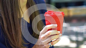 Woman outdoors holds a red plastic cup in her hand.