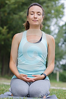 woman outdoors kneeling in meditation