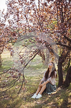 Woman Outdoors in Park Near Spring Blossom Tree