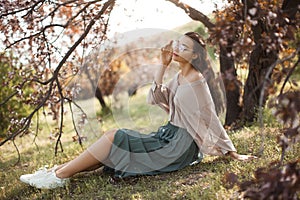 Woman Outdoors in Park Near Spring Blossom Tree