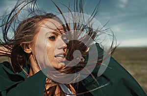 Woman outdoors with tousled wind blown hairs