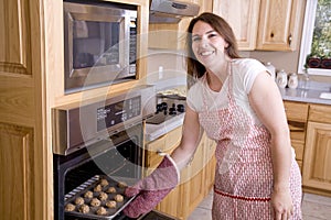 Woman by oven with cookies