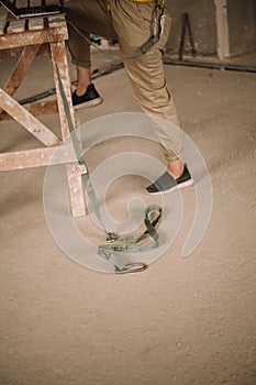 Woman in overalls leans on wooden structure