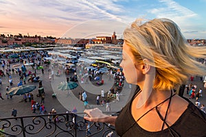 Woman overlooking Jamaa el Fna market square in sunset, Marrakesh, Morocco, north Africa.