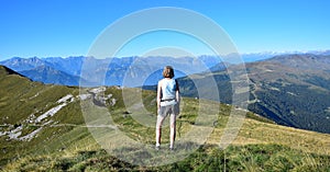 Woman overlooking mountains and the Alps from Monte Guglielmo. Lago d`Iseo, Brescia, Lombardy, Italy