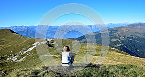 Woman overlooking mountains and the Alps from Monte Guglielmo. Lago d`Iseo, Brescia, Lombardy, Italy