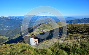 Woman overlooking other mountain summits from Monte Guglielmo. Lago d`Iseo, Brescia, Lombardy, Italy