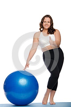 Woman is overweight with blue ball fitness