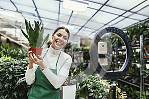 Woman owner on Live Streaming on mobile application by mobile phone for sell flower at flower shop