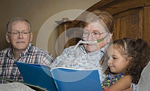 Woman on oxygen reads with family