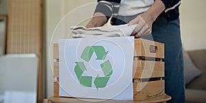 Woman pack box with used clothes for reuse. Reusing, recycling material and reducing waste in fashion, second hand photo