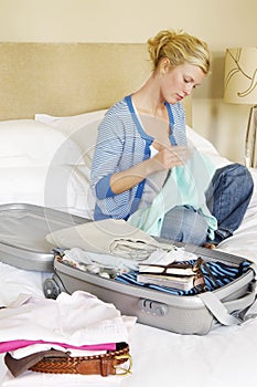 Woman With Packed Suitcase On Bed