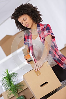 woman packing cardboard box at home