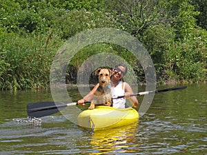 Woman paddler with dog in yellow kayak