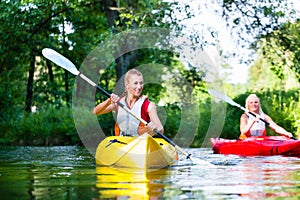 Woman paddling with canoe on forest river