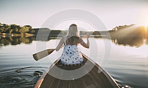 Woman paddling the canoe on lake, copy space