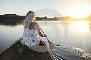Woman paddling the canoe on lake, copy space