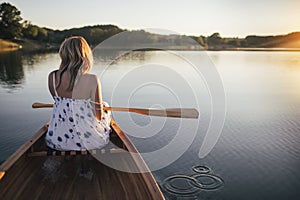 Woman paddling the canoe on lake, copy space