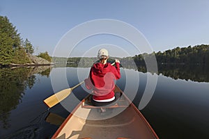 Woman Paddling a Canoe on a Northern Ontario Lake photo