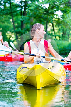 Woman paddling with canoe on river