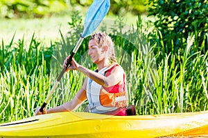 Woman paddling with canoe on river