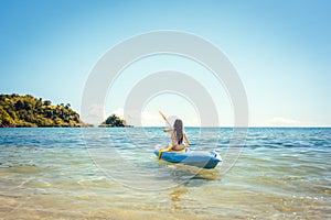 Woman paddling on a kayak on sea in clear water
