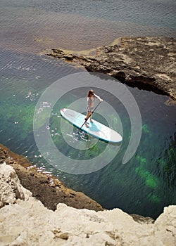 Woman Paddling on SUP board in a sea.