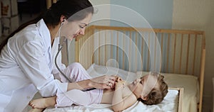 Woman paediatrician with stethoscope do health checkup of baby