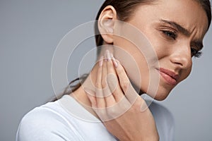 Woman In Pain. Beautiful Girl Feeling Toothache, Jaw, Neck Pain photo