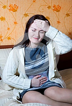 Woman with pain in her belly and head