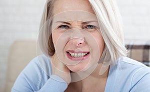 Woman with pain in her neck, medical shot at home. Concept photo with indicating location of the pain.