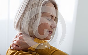 Woman with pain in her neck, medical shot at home. Concept photo with indicating location of the pain.