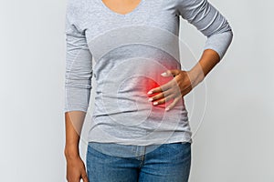 Woman in pain holding her stomach on the left side