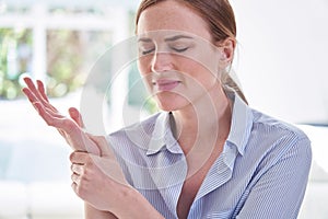 Woman In Pain Holding Wrist Suffering With Repetitive Strain Injury