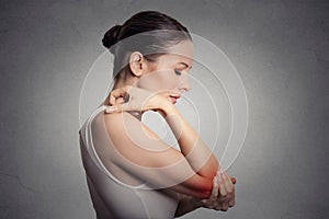 Woman with painful elbow on gray background