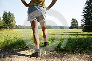 Woman with painful varicose veins on legs resting on a walk through nature