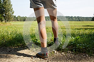 Woman with painful varicose veins on legs resting on a walk through nature photo