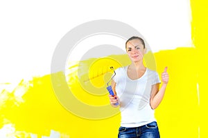 Woman painter for painting the walls, stands with a roller in hand smiling