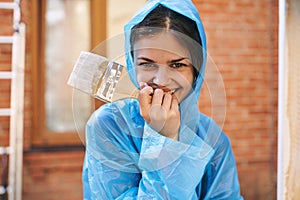 woman painter in protective clothing painting wood interior