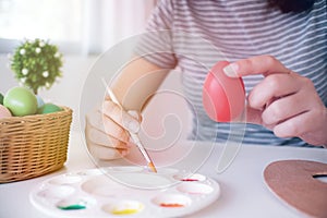 Woman painting Easter eggs at home. family preparing for Easter.