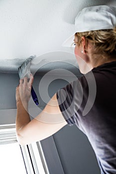 Woman Painting the Edges of the Ceiling