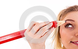 Woman painting eyebrows using regular pencil