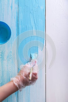 Woman painting with a paint brush wooden boards