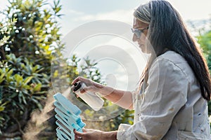 Woman painting polystyrene letters with paint on spray outdoors photo