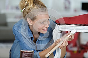 woman painting renewing chair at home