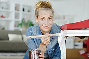 woman painting renewing chair at home