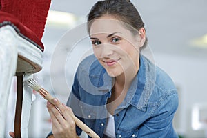 woman painting renewing chair at home