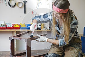 woman painting and restoring furniture