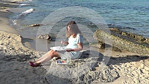 Woman painting sea on the beach